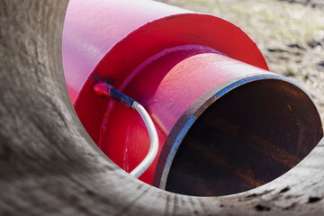 Wall Mural - Insulated pipe. Large metal pipes with a plastic sheath at a construction site. Modern pipeline for supplying hot water and heating to a residential area. Close-up.