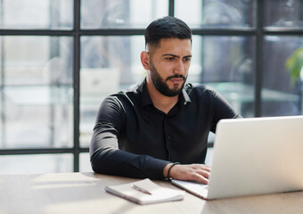 Bearded young businessman working on modern office. Consultant man thinking looking in monitor computer