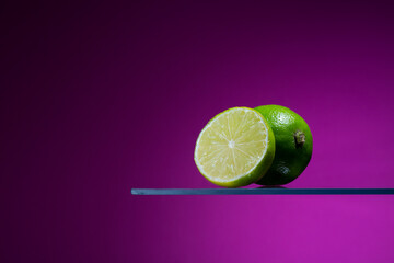 Wall Mural - Fresh lime fruits with magenta color background