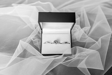 3 engagement rings, diamond and silver rings for use in wedding ceremonies of the bride and groom Arranged in a blue box, perched on the bed veil.