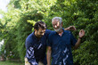 © amorn - Happy senior father and adult son embracing and talking outdoor garden. Two happy men spending time together in the park. Happy family, holiday and people concept