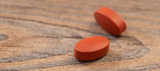 two pills on old wooden background