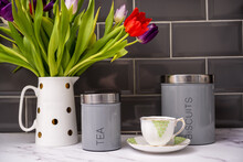 Still Life Lifestyle Tea And Biscuits In The Morning With Fresh Tulips In A White Jug On A Marble Kitchen Top