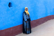 Nubian girl stands infant of Nubian blue house in aswan,Egypt