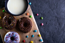 A Cup Of Milk With Donuts On A Dark Background