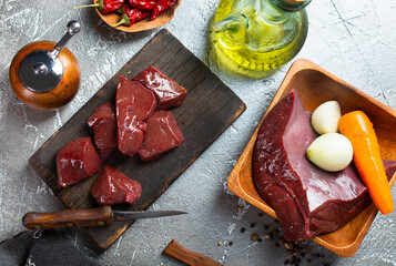 Poster - Raw liver on slate board on wooden background top view