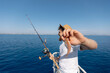 © Parilov - Fisherman is frustrated with catch of small fish for line in blue sea. Sad and disappointed face of man on fishing trip