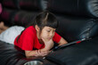 © waranyu - kid is addicted to tablet, little girl playing smartphone, kid use telephone, watching cartoon