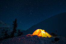 A Headlamp Is Used To Light Up A Tent Below A Starry Night Sky In British Columbia, Canada.