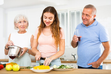 Wall Mural - Happy family in the kitchen having fun and cooking together