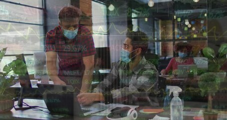 Canvas Print - Animation of trading board moving over caucasian male coworkers in masks discussing over laptop