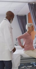 Poster - Vertical video of african american male doctor examining senior caucasian female patient at hospital