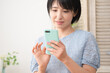 © aijiro - スマートフォンを操作する若い女性