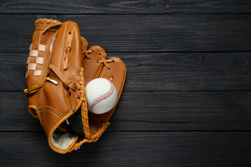 Sticker - Catcher's mitt and baseball ball on black wooden table, top view with space for text. Sports game