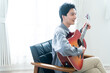 Leinwandbild Motiv アコースティックギターを弾く若い男性