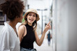 © krumanop - Happy girl helping to a tourist who asks direction in the street. Using public maps to find vacation destinations. Travel and journey concept.