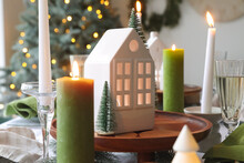 Christmas Table Setting With Candle Holder And Fir Trees In Dining Room, Closeup