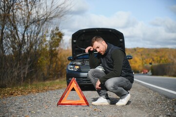 Wall Mural - A young man with a black car that broke down on the road,copy space.