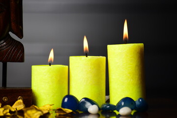 Wall Mural - yellow candles burning on dark background