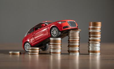 Wall Mural - Red toy car and coins on the desk.