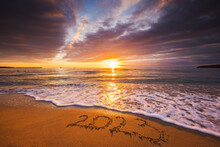 Happy New Year 2023 Concept, Lettering On The Beach. Written Text On The Sea Beach At Sunrise.