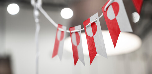 A garland of Greenland national flags on an abstract blurred background