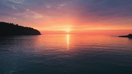 Wall Mural - Aerial view flying above surface of tropical sea with beautiful sunset glowing in summer