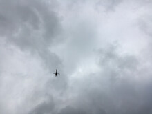 Low Angle View Of Silhouette Helicopter Flying Against Cloudy Sky