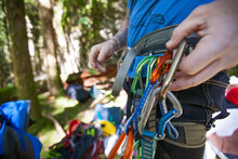 A climber clips a carabiner quickdraw on to his harness.