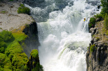 A Man Kayaks Down Lower Mesa Falls In Idaho On The Henry's Fork River.