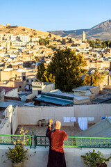 Wall Mural - Man on the rooftop enjoying view of Fez old arabic medina, Morocco, Africa