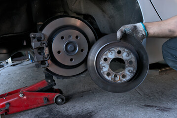 Wall Mural - Replacing brake discs on a car. Removed the old brake disc from the car and installed the new brake disc. Car maintenance