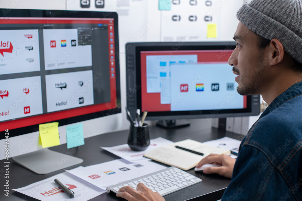 Asian graphic designer working on computer drawing sketches logo design ...