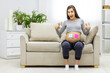 © Andrii - Photo of positive pregnant woman with pink and blue papers on the stomach which mean gender of future baby.
