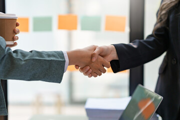 Business People standing, congratulating shaking hands confirming the agreement of doing business together. and propose new projects.