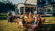 © Gorodenkoff - Group of Multiethnic Diverse People Having Fun, Communicating with Each Other and Eating at Outdoors Dinner. Family and Friends Gathered Outside Their Home on Warm Summer Day.
