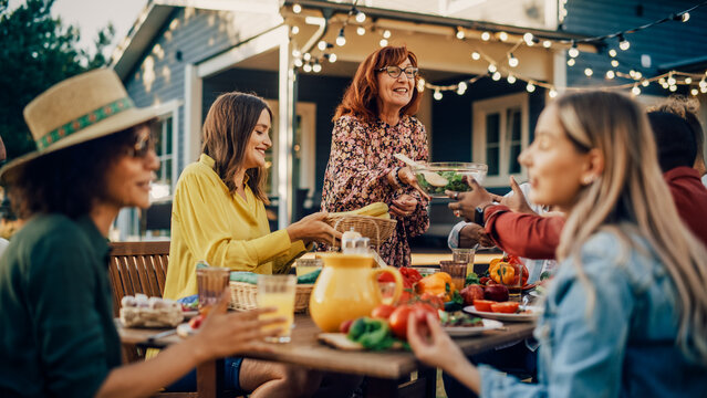 Fototapete - Family and Multiethnic Diverse Friends Gathering Together at a Garden Table. People Eating Grilled and Fresh Vegetables, Sharing Tasty Salads for a Big Family Celebration with Relatives.