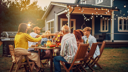 Wall Mural - Family and Multiethnic Diverse Friends Gathering Together at a Garden Table Dinner. Old and Young People Toasting and Clinking Glasses with Fresh Orange Juice and Celebrating an Event.