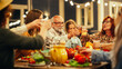 © Gorodenkoff - Family and Multicultural Diverse Friends Gathering Together at a Garden Dinner Party. Old and Young People Raising and Clinking Glasses to Celebrate a Festive Occasion.