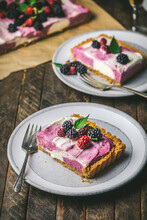 Cheesecake Slices And Berries On Serving Plates With Forks