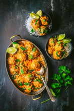 Chicken Meatballs In Curry Sauce In Serving Bowl With Noodles And Lime Slices