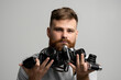 © Volodymyr - Close up portrait of man holding a old vintage film cameras.