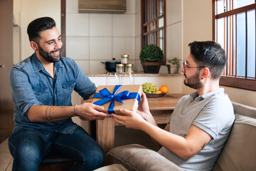 beautiful gay man receiving gift box from partner at home