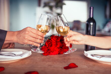 Romantic Dinner Table Setup For Couple. Man & Woman Hold Glass Of Wine. Concept For Valentine's Day And Date