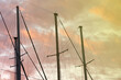 masts of a yacht without sails against the background of a sunset cloudy sky