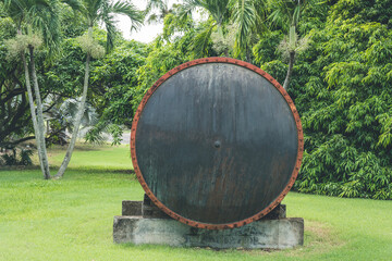 Big metal decorative barrel with rusted rings, used in distillery. Barrel as an exposition in a park