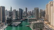 Panorama showing aerial view to Dubai marina skyscrapers around canal with floating boats timelapse