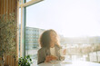 © D'Action Images - Young smiling african american girl drinking coffee and eating tasty croissant in a cozy cafe. Holidays, lunch time and vacation concept