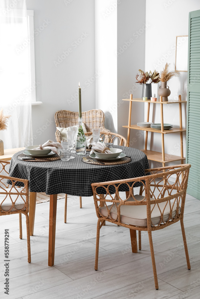 Beautiful table setting with burning candle in stylish room