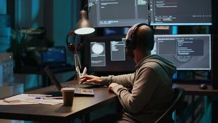 Funny programmer listening to music and playing air drums, fooling around in office. Young male coder having fun with instrument, acting silly and careless singing song on headset.